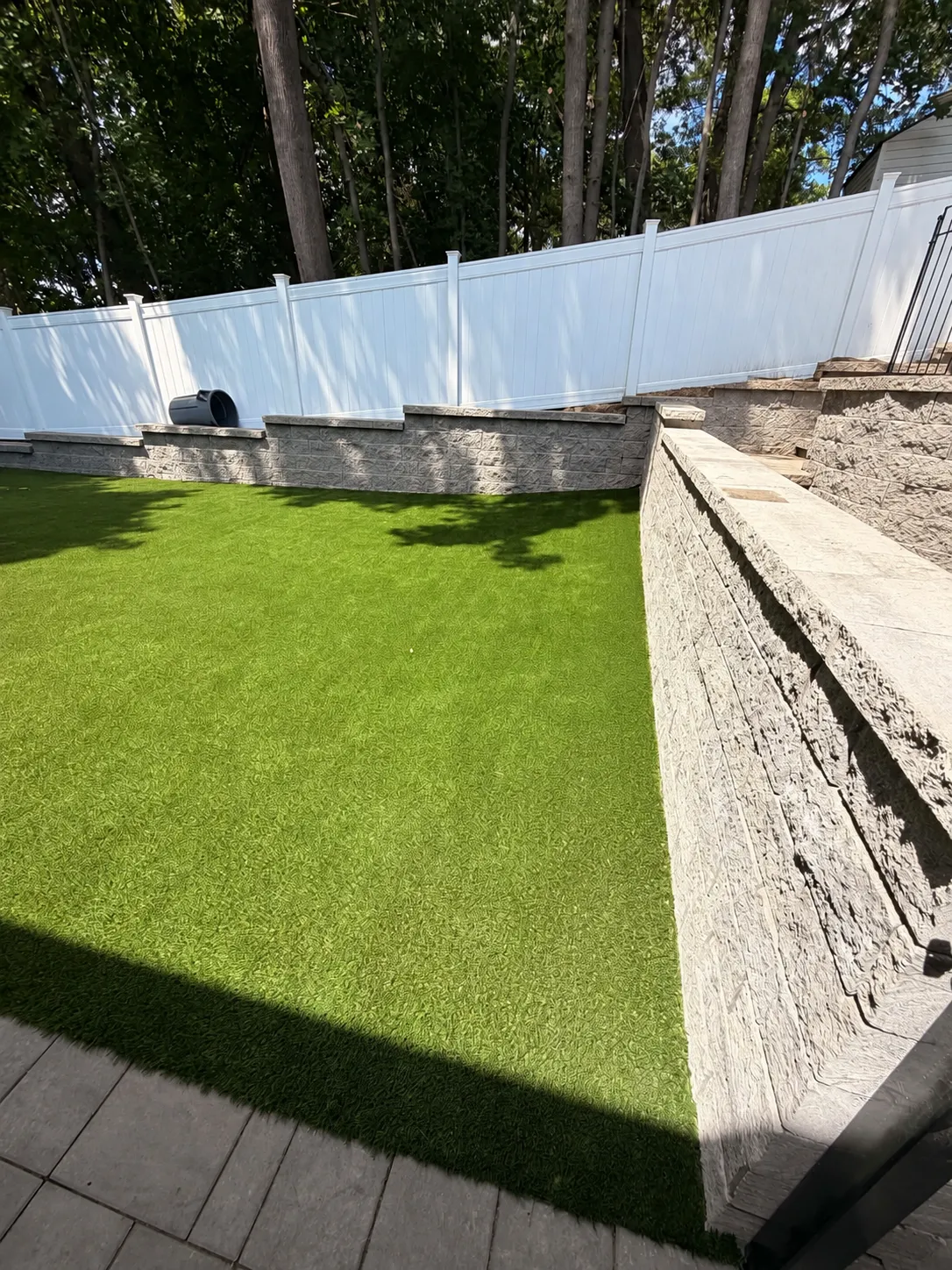 Finished landscape wall beside an artificial grass lawn